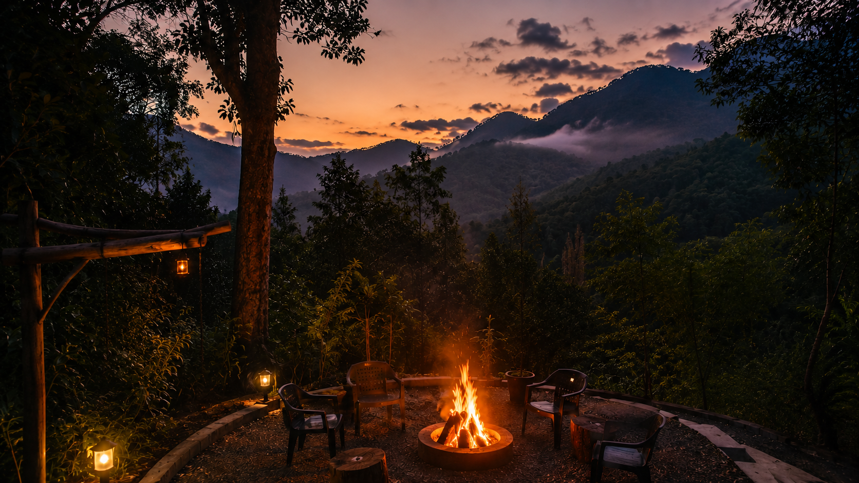 A crackling bonfire surrounded by chairs at dusk, with misty hills silhouetted against an orange sunset sky