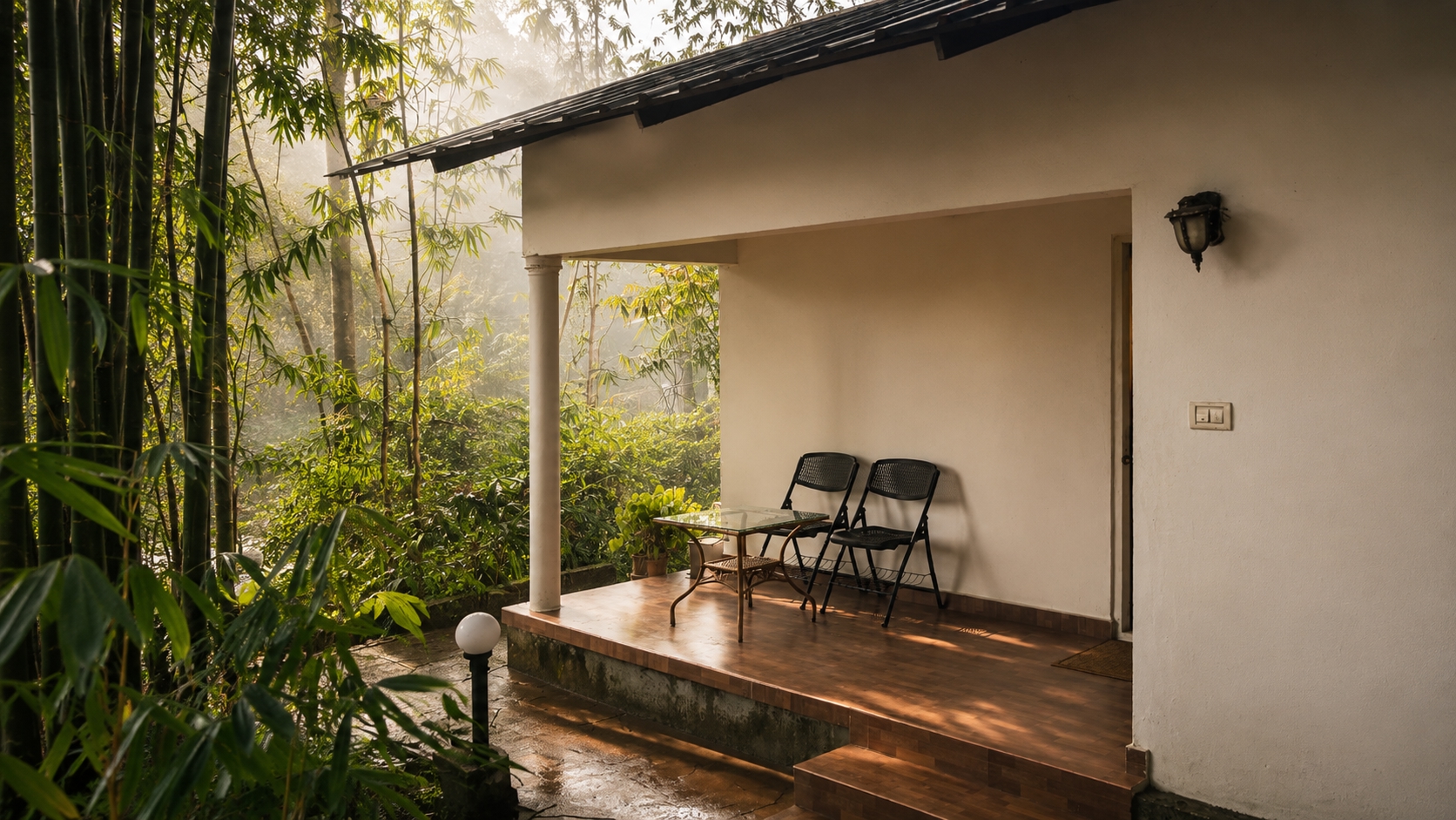 Eyrie Cottage's whitewashed veranda with folding chairs, framed by bamboo and morning mist